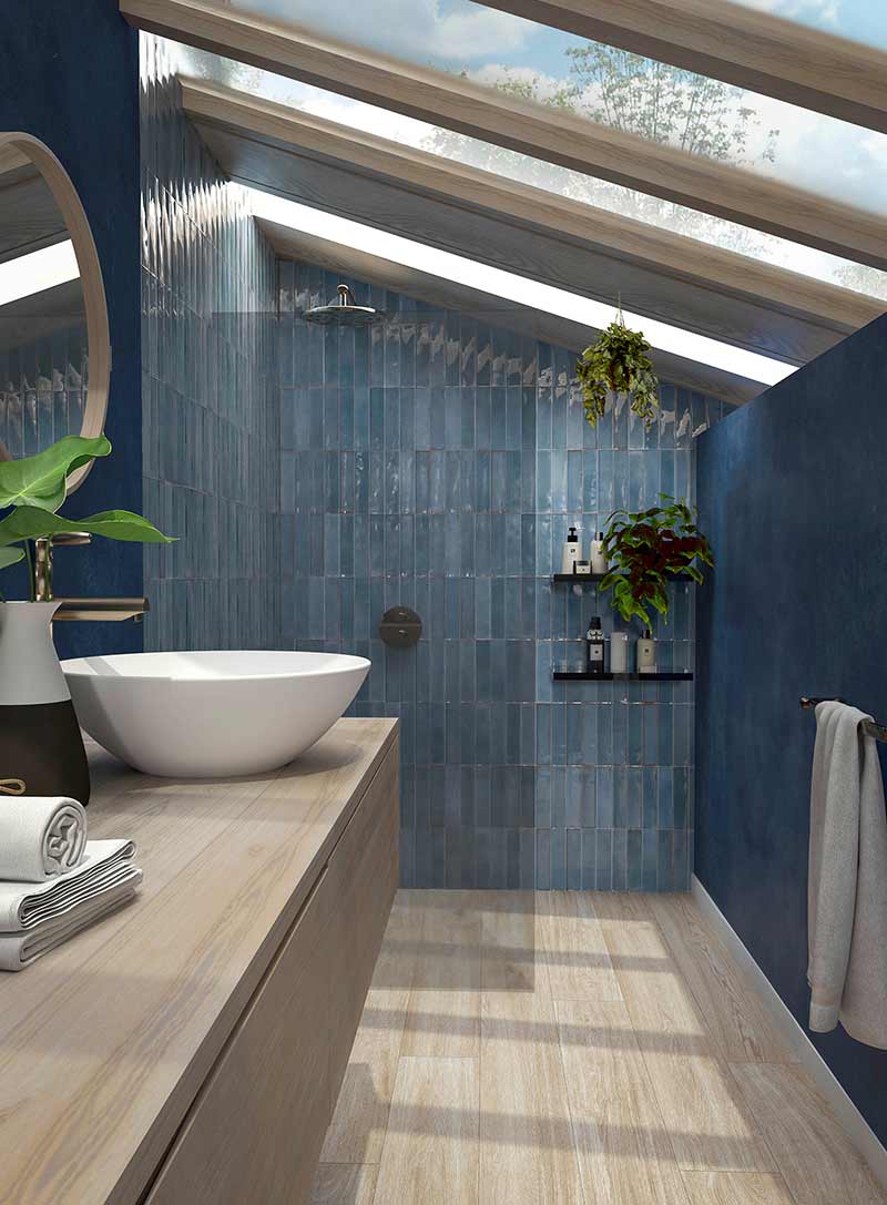 Une salle de bain sous les combles avec du carrelage mural bleu