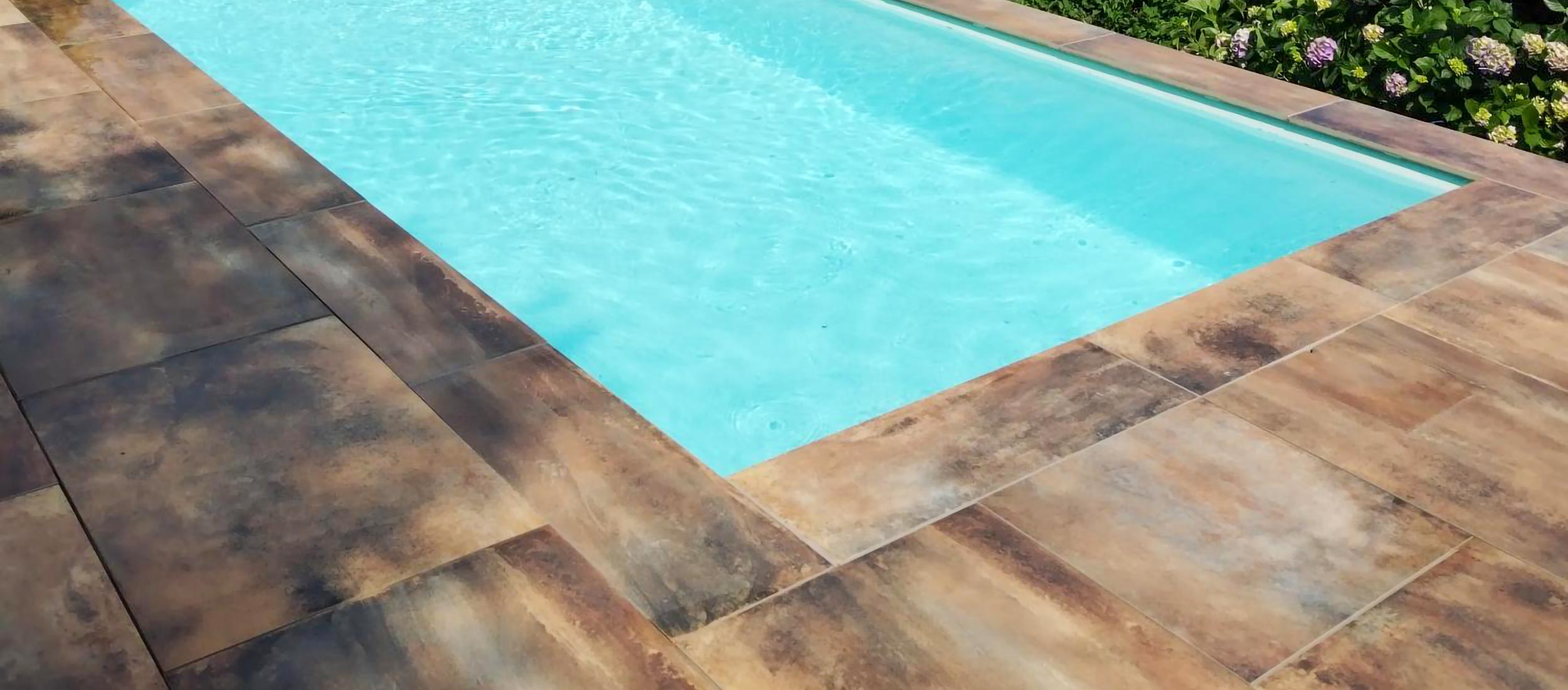 Vue d'ensemble de la terrasse et de la piscine après rénovation par Carrelage et Bain Junet à Lyon.