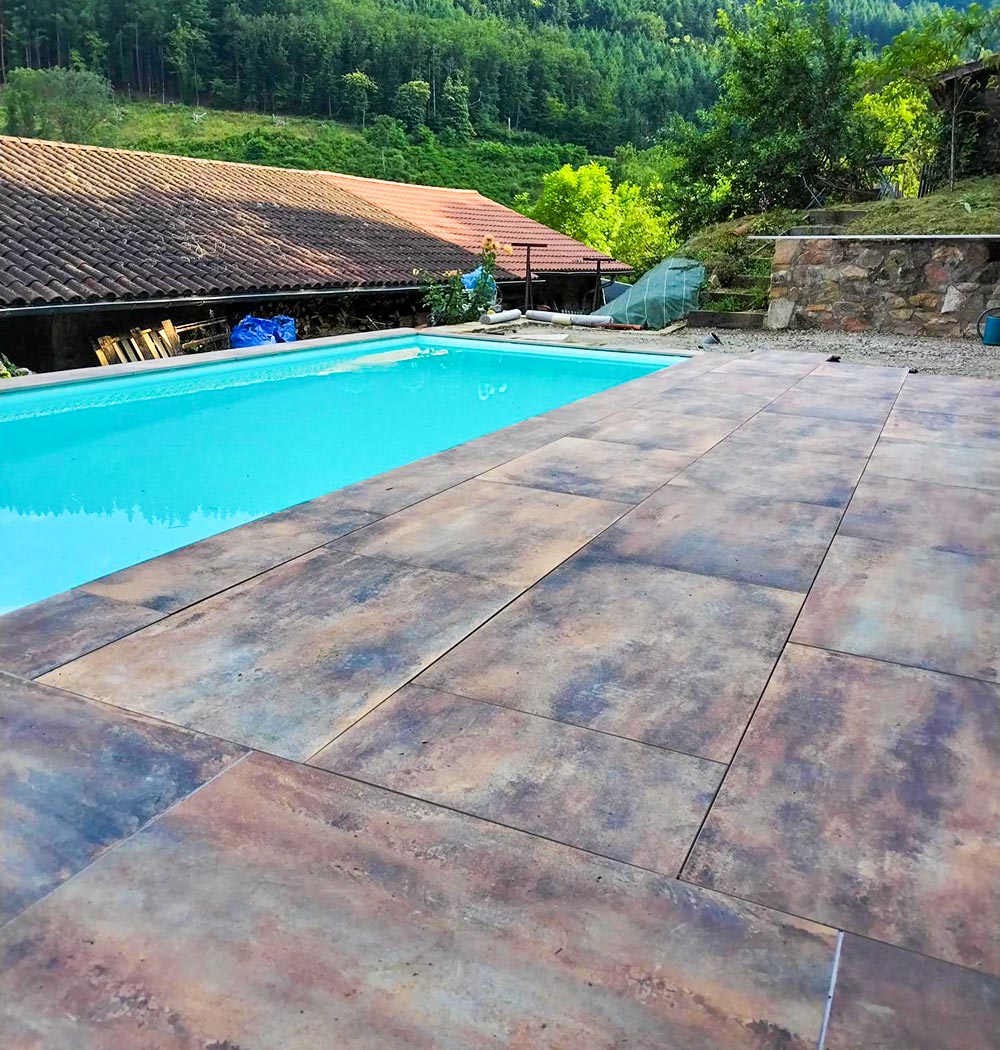 Détail du carrelage posé sur la terrasse piscine, une réalisation client de Carrelage et Bain Junet.