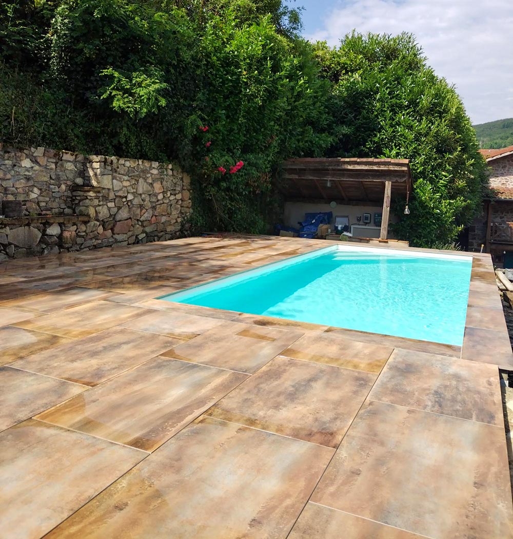 Terrasse et plage piscine rénovées avec style, grâce au carrelage choisi chez Carrelage et Bain Junet à Lyon.