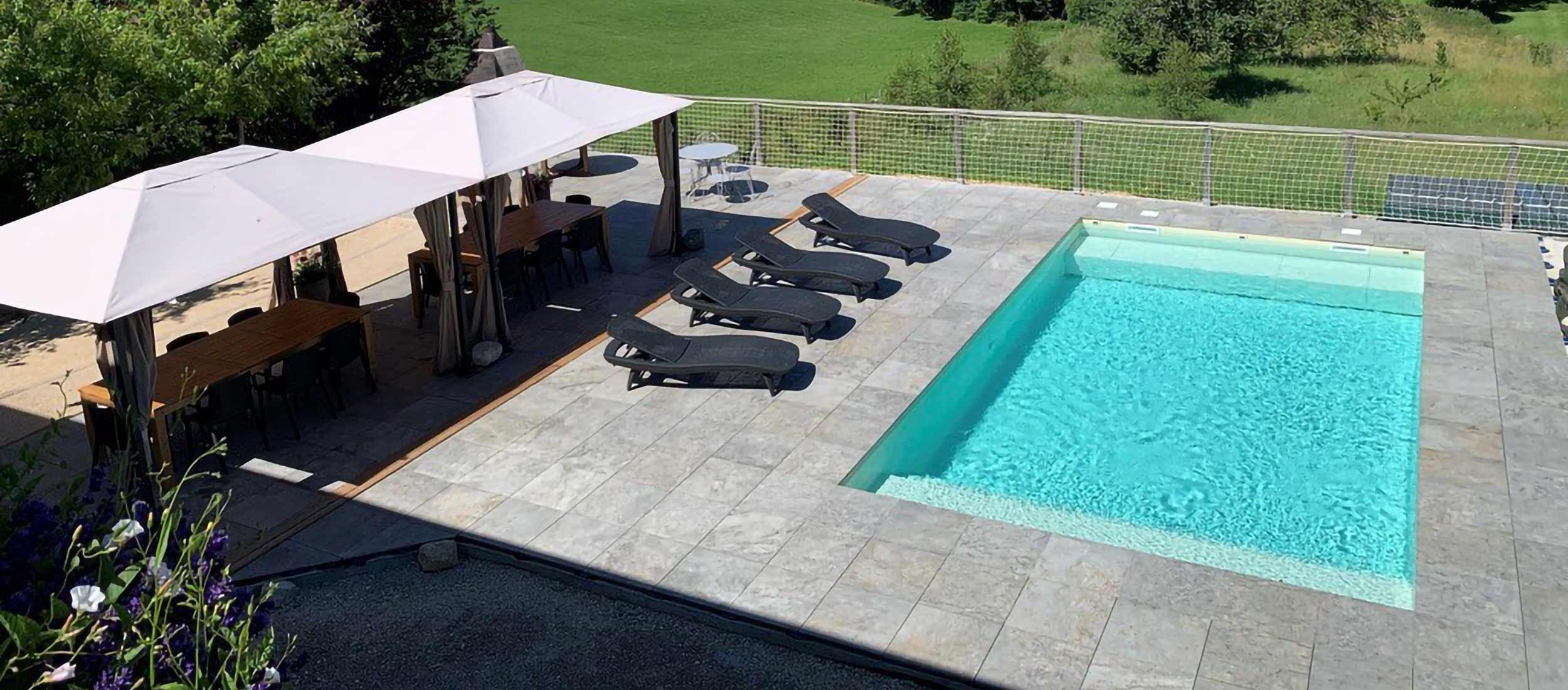 Rénovation piscine : carrelage imitation pierre pour un espace extérieur harmonieux, réalisé par Le Carrelage Bugiste à Belley.